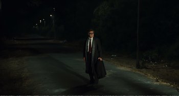 Movie still from “City of Women” (1980), directed by Federico Fellini – A man walking down a street at night holding a suit case; Wide shot, Low angle