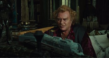 Movie still from “City of Women” (1980), directed by Federico Fellini – A man sitting in front of a toy train; Medium shot, Over the shoulder angle