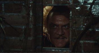 Movie still from “City of Women” (1980), directed by Federico Fellini – A person looking through a window; Close Up shot, Low angle