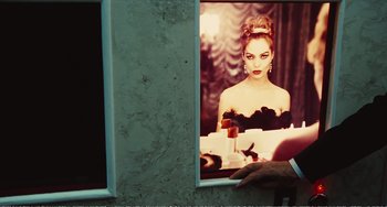 Movie still from “City of Women” (1980), directed by Federico Fellini – A woman is looking in the mirror of a bathroom; Medium shot, Over the shoulder angle