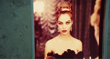 Movie still from “City of Women” (1980), directed by Federico Fellini – A woman in a black dress with a tiara on her head; Close Up shot, Over the shoulder angle