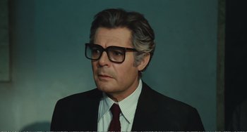 Movie still from “City of Women” (1980), directed by Federico Fellini – An older man wearing glasses and a suit; Close Up shot, Low angle