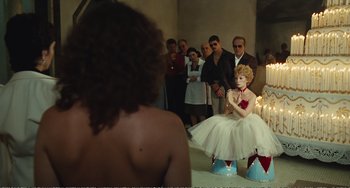 Movie still from “City of Women” (1980), directed by Federico Fellini – A group of people standing around in a room; Wide shot, Over the shoulder angle