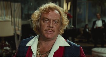 Movie still from “City of Women” (1980), directed by Federico Fellini – An older man with blonde hair and a mustache; Close Up shot, Over the shoulder angle