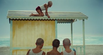 Movie still from “City of Women” (1980), directed by Federico Fellini – A group of young men standing on top of a building; Wide shot, High angle
