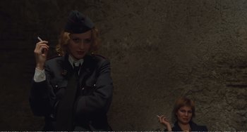 Movie still from “City of Women” (1980), directed by Federico Fellini – A woman in a military uniform smoking a cigarette next to another woman; Medium shot, Low angle