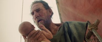 Movie still from “Clash of the Titans” (2010), directed by Louis Leterrier – An old man holding a baby in his arms; Close Up shot, Low angle