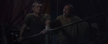 Movie still from “Clash of the Titans” (2010), directed by Louis Leterrier – Two men are holding onto a rope while standing; Medium shot, Low angle