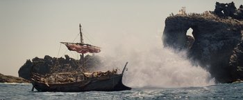 Movie still from “Clash of the Titans” (2010), directed by Louis Leterrier – A boat in the ocean with a large wave coming from it; Extreme Wide shot, Low angle