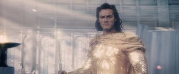 Movie still from “Clash of the Titans” (2010), directed by Louis Leterrier – A man with long black hair holding a sword in his hand; Medium shot, Low angle