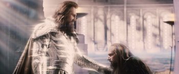 Movie still from “Clash of the Titans” (2010), directed by Louis Leterrier – A man in a metal suit is touching another man in a metal suit; Medium shot, Over the shoulder angle