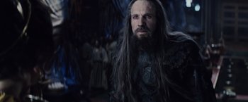Movie still from “Clash of the Titans” (2010), directed by Louis Leterrier – A man with long hair and a long beard; Close Up shot, Over the shoulder angle