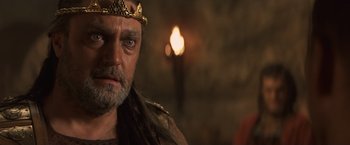 Movie still from “Clash of the Titans” (2010), directed by Louis Leterrier – A person wearing a crown with a light in the background; Close Up shot, Over the shoulder angle
