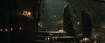 Movie still from “Clash of the Titans” (2010), directed by Louis Leterrier – A man standing in the middle of a room with candles; Wide shot, High angle