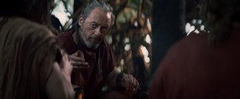 Movie still from “Clash of the Titans” (2010), directed by Louis Leterrier – An older man sitting in a forest talking to another man; Close Up shot, Over the shoulder angle