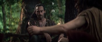 Movie still from “Clash of the Titans” (2010), directed by Louis Leterrier – A man sitting on the ground in front of a tree; Close Up shot, Over the shoulder angle