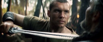 Movie still from “Clash of the Titans” (2010), directed by Louis Leterrier – A person holding a saw blade; Close Up shot, Low angle