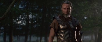 Movie still from “Clash of the Titans” (2010), directed by Louis Leterrier – A man with a beard wearing a leather vest; Medium shot, Over the shoulder angle