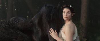 Movie still from “Clash of the Titans” (2010), directed by Louis Leterrier – A beautiful young woman standing next to a black horse; Close Up shot, Over the shoulder angle