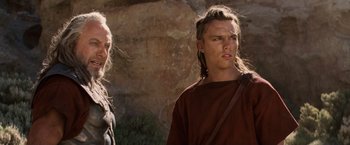 Movie still from “Clash of the Titans” (2010), directed by Louis Leterrier – A man with long hair stands next to another man with long hair; Close Up shot, Over the shoulder angle