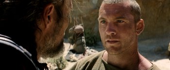 Movie still from “Clash of the Titans” (2010), directed by Louis Leterrier – Two men are standing in the desert looking at each other; Close Up shot, Over the shoulder angle