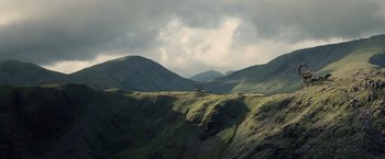 Movie still from “Clash of the Titans” (2010), directed by Louis Leterrier – A tractor on a green hillside under a cloudy sky; Extreme Wide shot, Low angle
