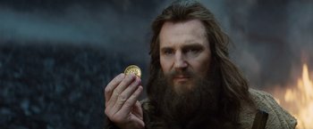 Movie still from “Clash of the Titans” (2010), directed by Louis Leterrier – A bearded man holding a coin in his hand; Close Up shot, Over the shoulder angle