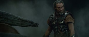 Movie still from “Clash of the Titans” (2010), directed by Louis Leterrier – A man with a dragon in the background; Close Up shot, Over the shoulder angle