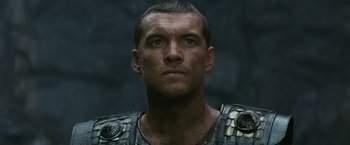 Movie still from “Clash of the Titans” (2010), directed by Louis Leterrier – A person wearing armor looking at the camera; Close Up shot, Low angle