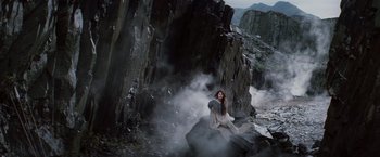 Movie still from “Clash of the Titans” (2010), directed by Louis Leterrier – A woman sitting on top of a large rock; Wide shot, High angle