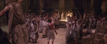 Movie still from “Clash of the Titans” (2010), directed by Louis Leterrier – A group of people dressed in robes and white robes are standing in front of a crowd; Wide shot, High angle