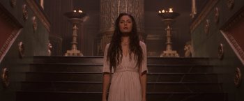 Movie still from “Clash of the Titans” (2010), directed by Louis Leterrier – A woman standing in front of stairs in a room; Medium shot, Low angle