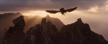 Movie still from “Clash of the Titans” (2010), directed by Louis Leterrier – A bird flying over a mountain range at sunset; Extreme Wide shot, High angle