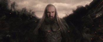 Movie still from “Clash of the Titans” (2010), directed by Louis Leterrier – A man with long hair and a beard is standing in front of some trees; Medium shot, Low angle