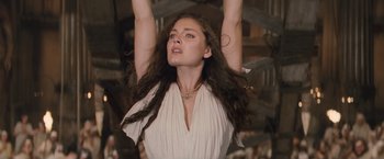 Movie still from “Clash of the Titans” (2010), directed by Louis Leterrier – A beautiful woman with long brown hair holding her arms up; Close Up shot, Low angle