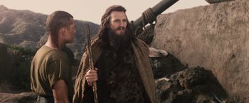 Movie still from “Clash of the Titans” (2010), directed by Louis Leterrier – A man with a long beard holding a wooden stick; Medium shot, Low angle