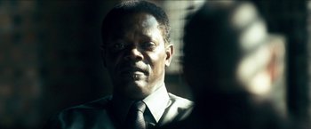 Movie still from “Cleaner” (2007), directed by Renny Harlin – A person wearing a suit and tie; Close Up shot, Over the shoulder angle