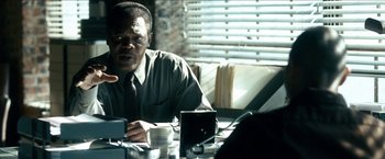 Movie still from “Cleaner” (2007), directed by Renny Harlin – A man sitting at a table with a cup of coffee; Close Up shot, Over the shoulder angle