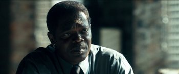 Movie still from “Cleaner” (2007), directed by Renny Harlin – A person wearing a suit and tie; Close Up shot, Over the shoulder angle
