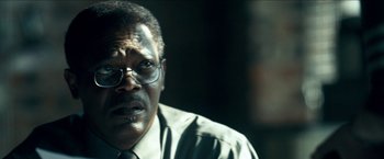 Movie still from “Cleaner” (2007), directed by Renny Harlin – An older man wearing glasses and a tie; Close Up shot, Over the shoulder angle
