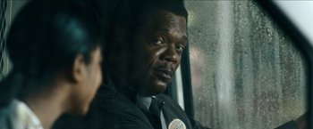 Movie still from “Cleaner” (2007), directed by Renny Harlin – A man in a suit and tie sitting on a train; Close Up shot, Over the shoulder angle