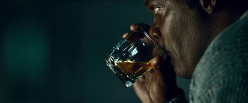 Movie still from “Cleaner” (2007), directed by Renny Harlin – A man holding a glass of whiskey in his hand; Extreme Close Up shot, Over the shoulder angle