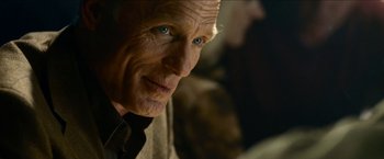 Movie still from “Cleaner” (2007), directed by Renny Harlin – An older man with a blue eye stares at the camera; Close Up shot, Over the shoulder angle