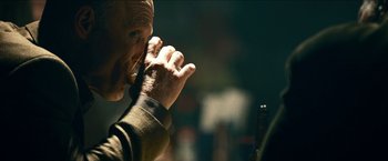 Movie still from “Cleaner” (2007), directed by Renny Harlin – An older man holding a pen in his mouth; Extreme Close Up shot, Over the shoulder angle
