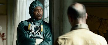 Movie still from “Cleaner” (2007), directed by Renny Harlin – A man in a green lab coat looking at a man in a yellow lab coat; Close Up shot, Over the shoulder angle