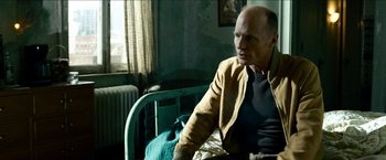 Movie still from “Cleaner” (2007), directed by Renny Harlin – An older man sitting on a hospital bed in a room; Medium shot, Over the shoulder angle