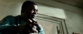 Movie still from “Cleaner” (2007), directed by Renny Harlin – A black man is holding his hands out; Close Up shot, Low angle
