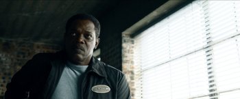 Movie still from “Cleaner” (2007), directed by Renny Harlin – A man standing in front of a window in a room; Close Up shot, Low angle