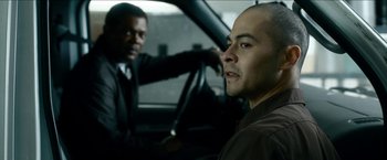 Movie still from “Cleaner” (2007), directed by Renny Harlin – Two men in suits in a car looking at each other; Close Up shot, Over the shoulder angle
