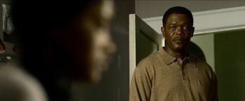 Movie still from “Cleaner” (2007), directed by Renny Harlin – A man standing in front of a mirror in a room; Close Up shot, Over the shoulder angle